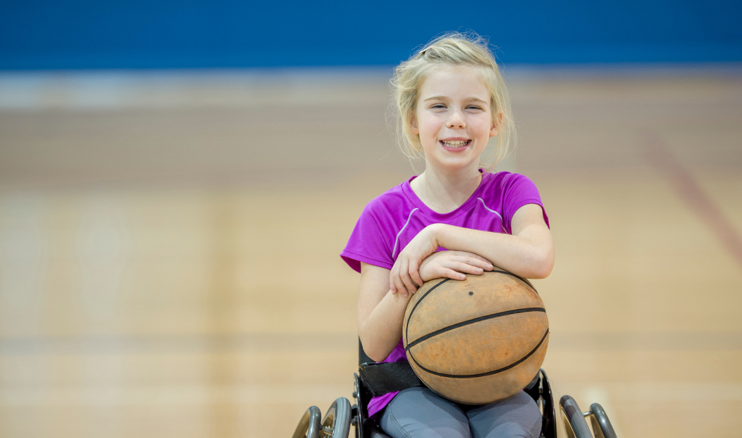 girl in wheelchair holding a basketball